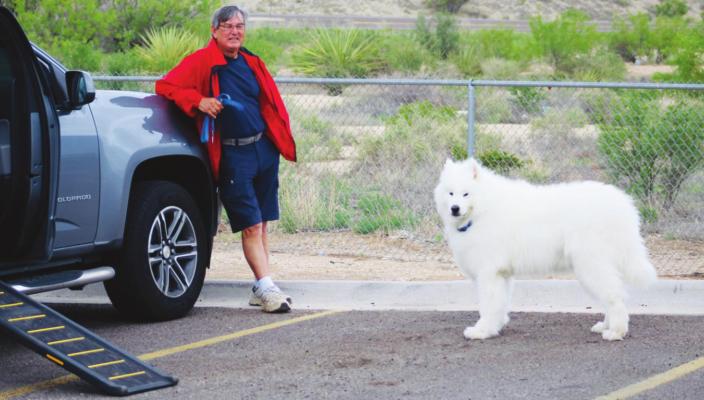 David Gonzales kept a close eye on his 85-pound companion Blue Boy at the Loves Travel stop on Monday. The fluffy white dog is a breed known as Samoyed. Photo by Jeremy Gonzalez