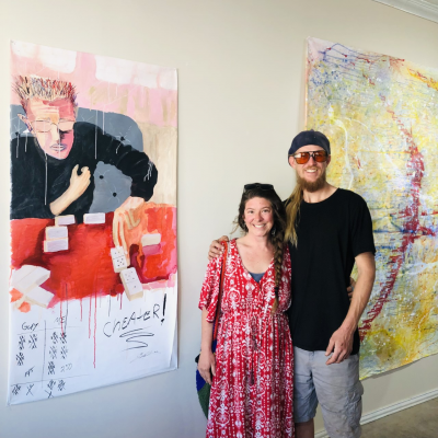 Travelers Leah and Oak viewed the works of local artist Steven Walker in the ChunkArts Studio located at 209 West 1st St. The traveling couple stood next to a painting of Fort Stockton native Ben Gallegos. Photo by Jeremy Gonzalez
